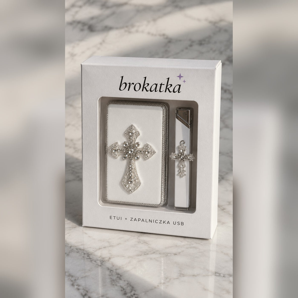 Białe etui na papierosy z krzyżem z kryształków i zapalniczka USB przy pudełku Brokatka